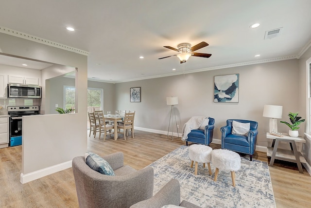 living room featuring ornamental molding, ceiling fan, and light hardwood / wood-style flooring