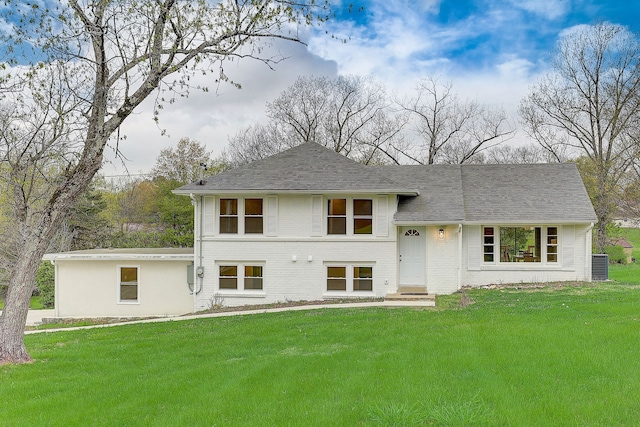 view of front of property with a front lawn and central air condition unit