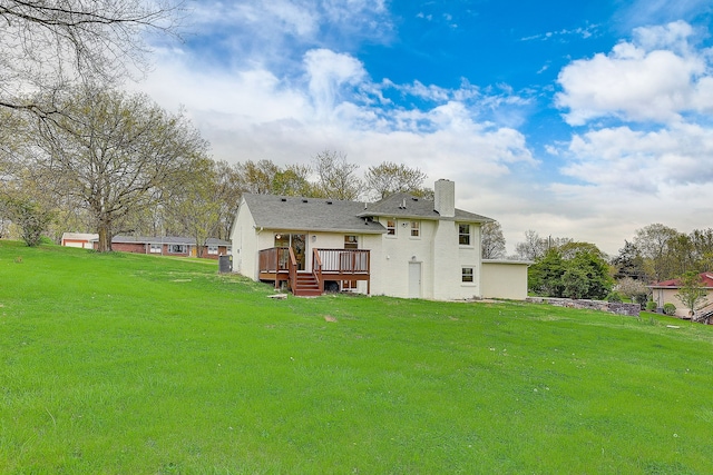 back of property with a lawn and a deck