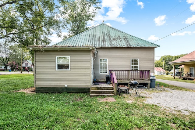 back of house with a wooden deck and a yard