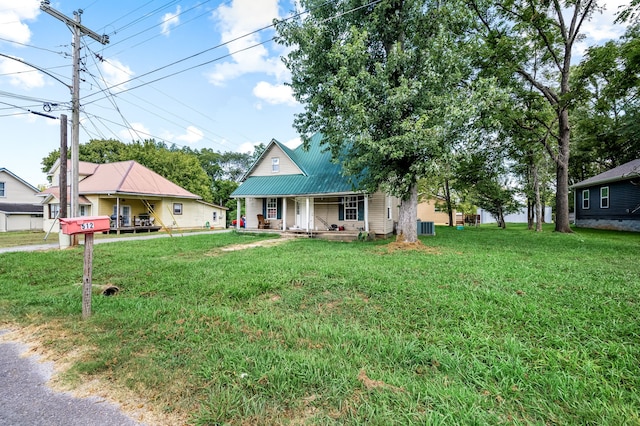 view of front of home with cooling unit, a front lawn, and covered porch