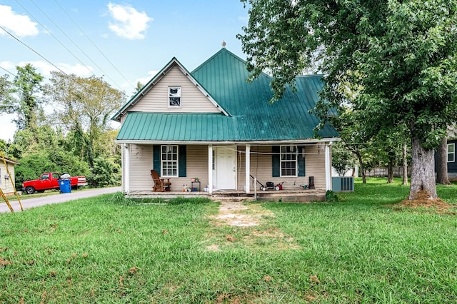 view of front facade with a front lawn, central air condition unit, and covered porch