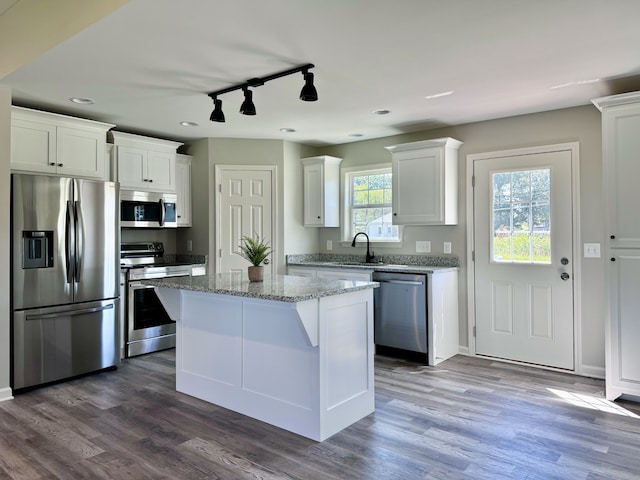 kitchen featuring a center island, dark wood-type flooring, stainless steel appliances, and white cabinets