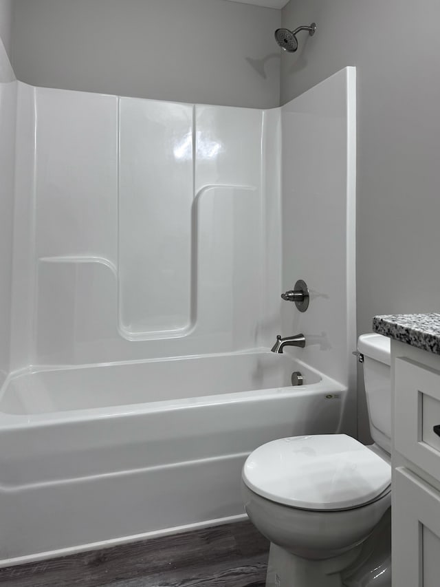 full bathroom featuring hardwood / wood-style floors, bathing tub / shower combination, vanity, and toilet