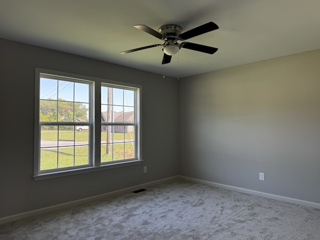 unfurnished room with carpet, ceiling fan, and a wealth of natural light