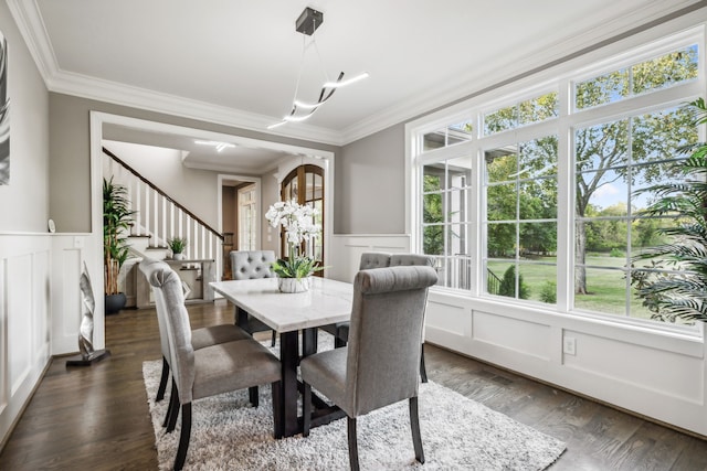 dining space with crown molding, dark hardwood / wood-style flooring, and plenty of natural light