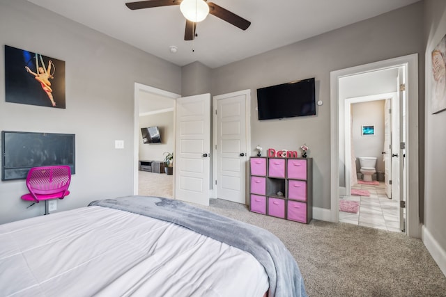 carpeted bedroom with ensuite bath and ceiling fan