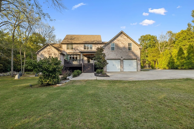 view of front facade with a deck, a garage, and a front yard