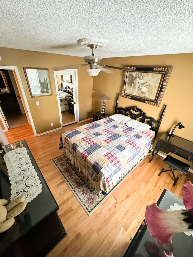 bedroom featuring a textured ceiling, ceiling fan, and hardwood / wood-style flooring