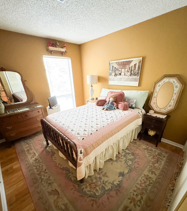 bedroom with a textured ceiling and hardwood / wood-style floors