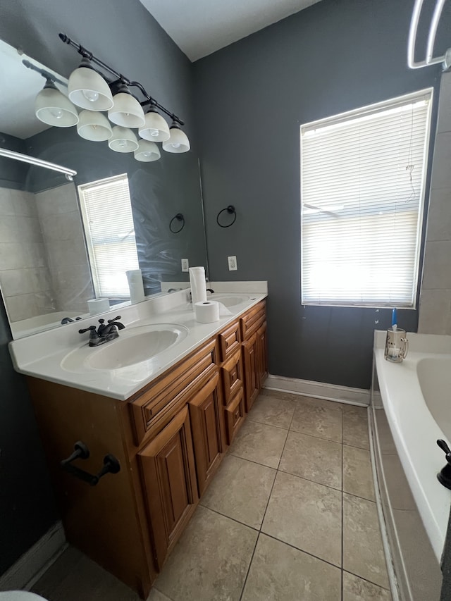 bathroom featuring tile patterned flooring, plenty of natural light, vanity, and a bathing tub