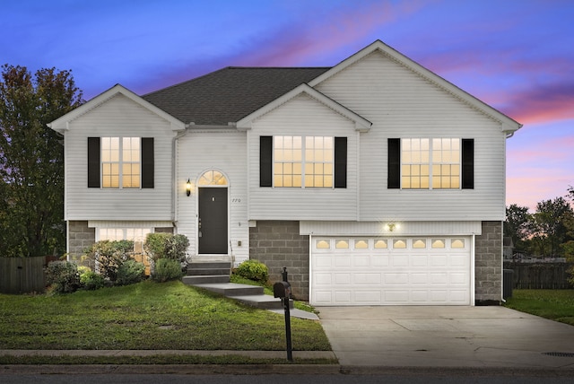 view of front of property featuring a garage and a lawn