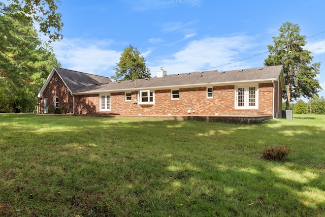 rear view of property featuring a yard