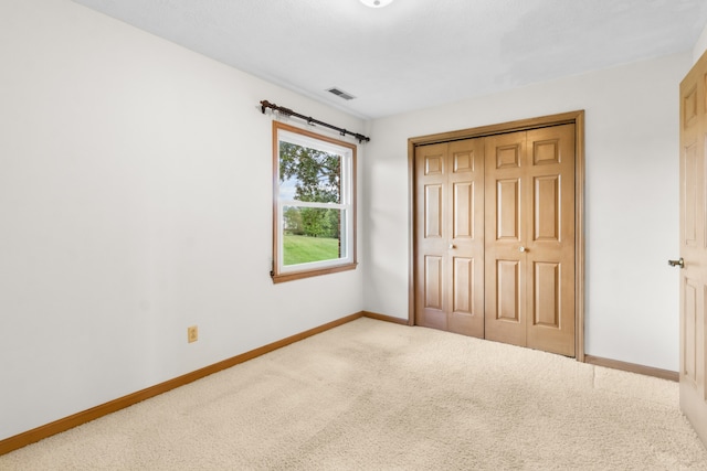 unfurnished bedroom featuring carpet and a closet