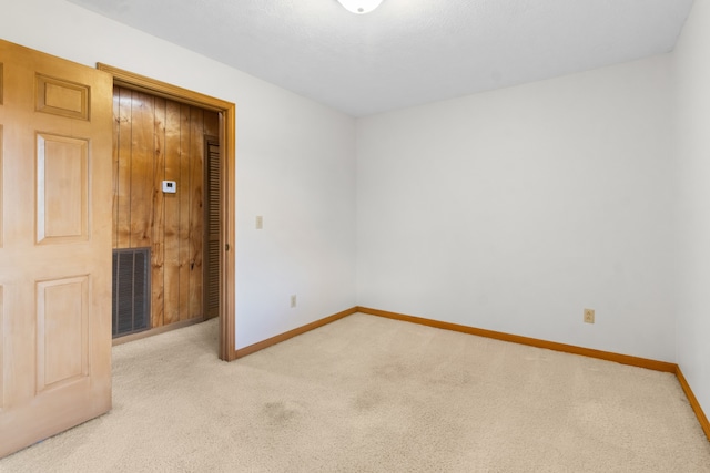 unfurnished room featuring light carpet