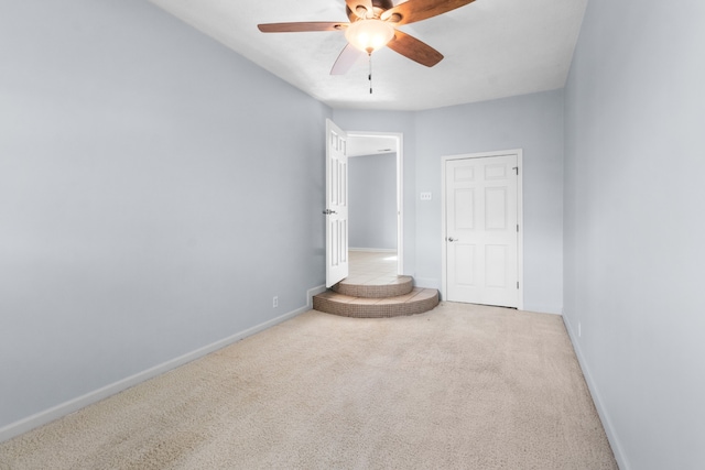 carpeted spare room with ceiling fan