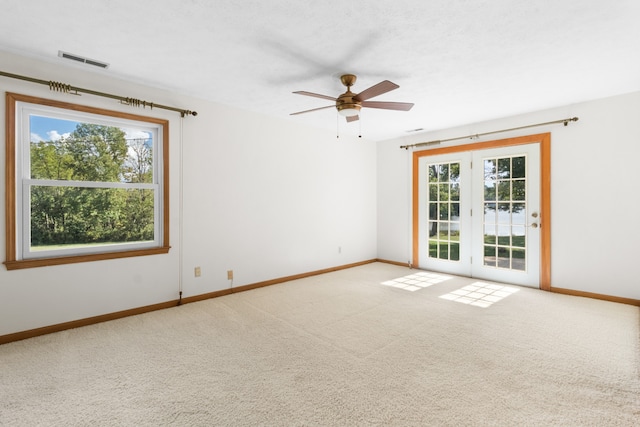 carpeted empty room featuring a wealth of natural light and ceiling fan