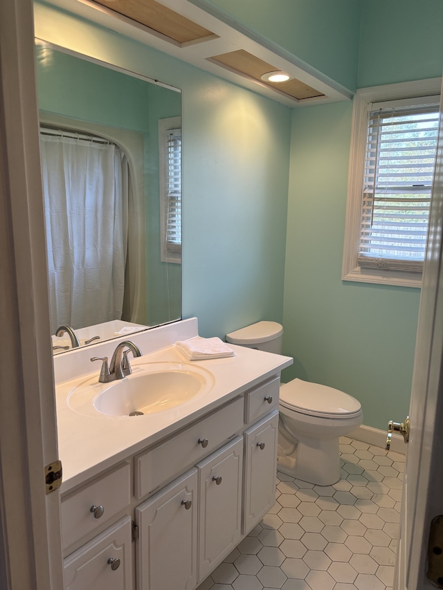 bathroom with vanity, tile patterned flooring, and toilet