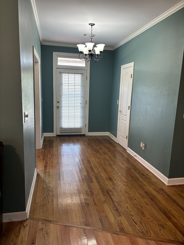 interior space featuring ornamental molding, dark wood-type flooring, and a chandelier