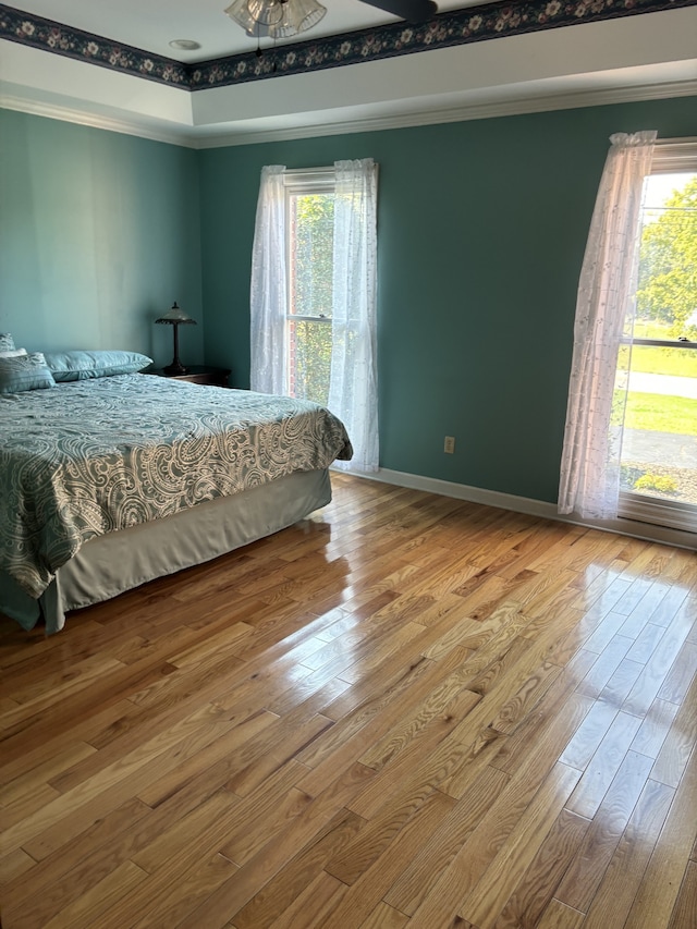 bedroom with ornamental molding and hardwood / wood-style floors