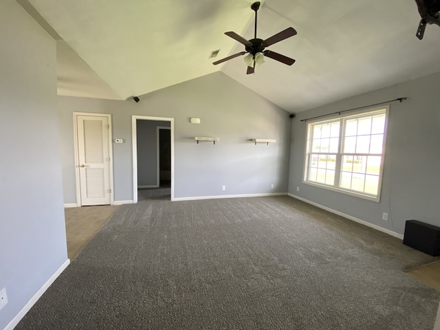 unfurnished living room with dark carpet, vaulted ceiling, and ceiling fan