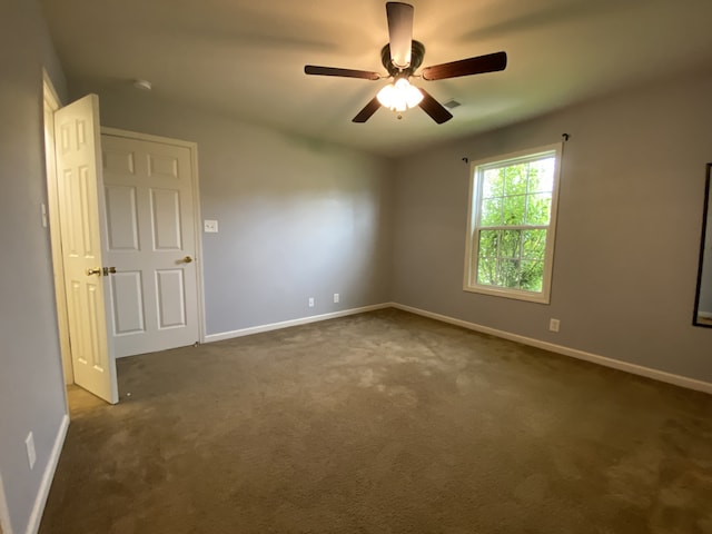 empty room with dark carpet and ceiling fan