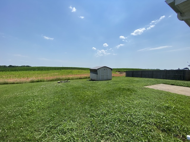 view of yard featuring a storage shed and a rural view