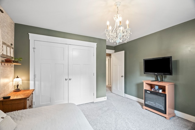 carpeted bedroom featuring a chandelier and a closet