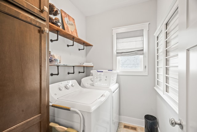 clothes washing area featuring independent washer and dryer, tile patterned floors, and cabinets