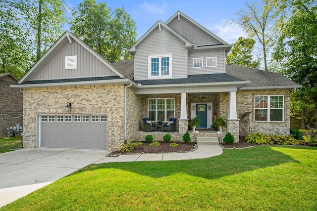 craftsman inspired home with a front lawn, covered porch, and a garage