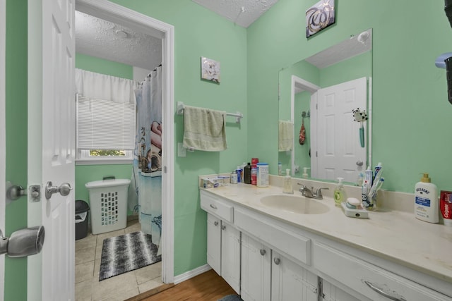 bathroom featuring a textured ceiling, tile patterned flooring, vanity, and curtained shower