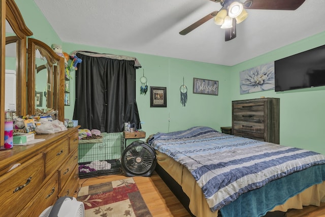 bedroom featuring ceiling fan, a textured ceiling, and light hardwood / wood-style floors