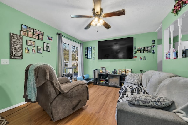 living room with a textured ceiling, wood-type flooring, and ceiling fan