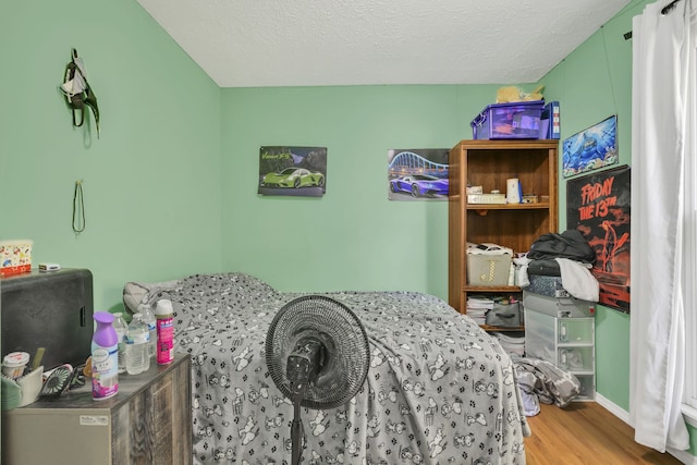 bedroom with wood-type flooring and a textured ceiling