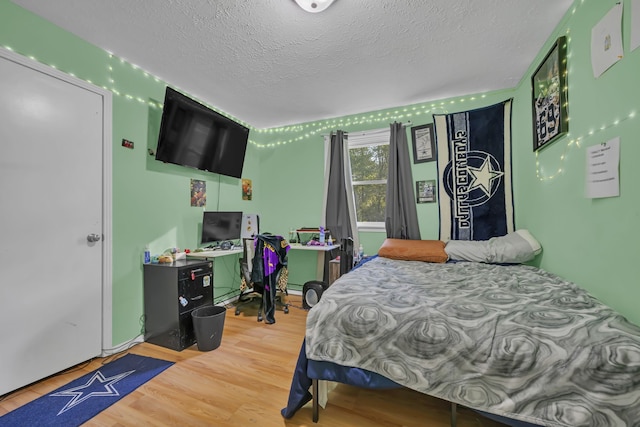 bedroom with a textured ceiling and hardwood / wood-style flooring