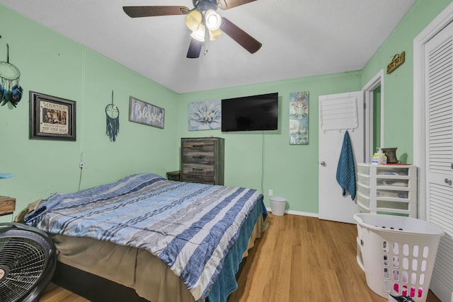 bedroom with a closet, light wood-type flooring, and ceiling fan