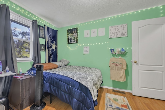 bedroom featuring a textured ceiling and hardwood / wood-style flooring