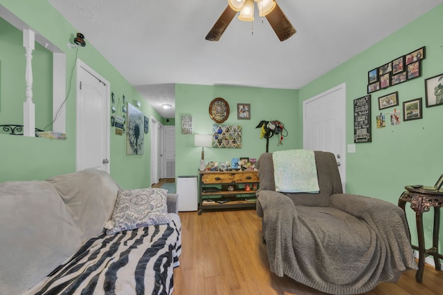 living room with ceiling fan and light hardwood / wood-style flooring