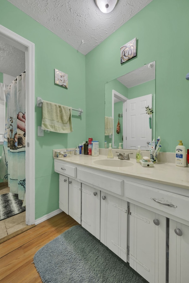 bathroom featuring vanity, a textured ceiling, and hardwood / wood-style flooring