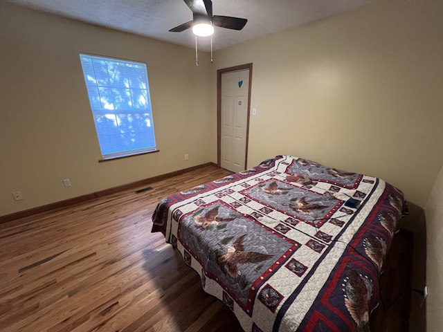 bedroom with wood-type flooring and ceiling fan