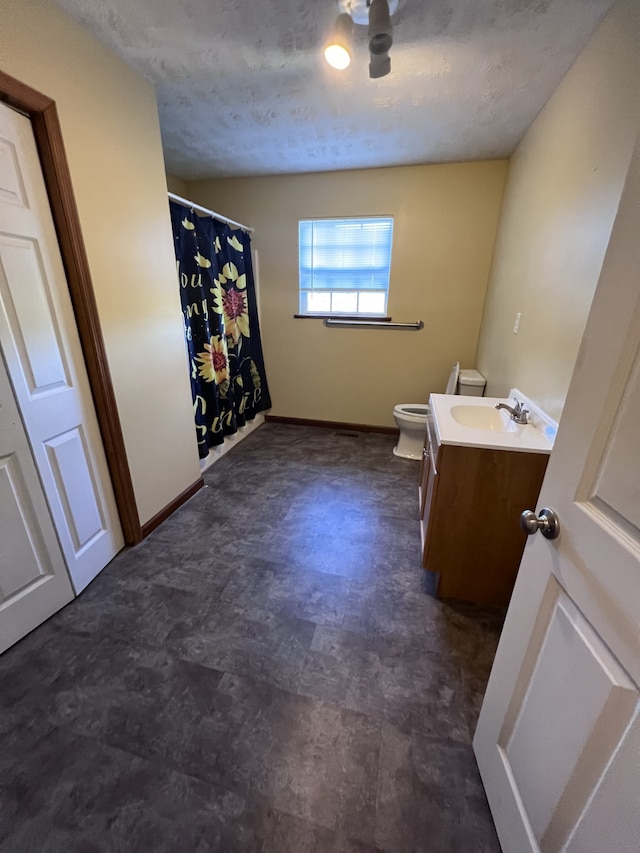 bathroom with walk in shower, vanity, toilet, and a textured ceiling