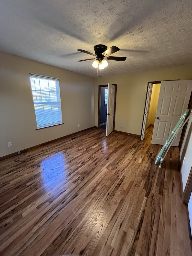 unfurnished bedroom featuring ceiling fan, hardwood / wood-style floors, and a textured ceiling