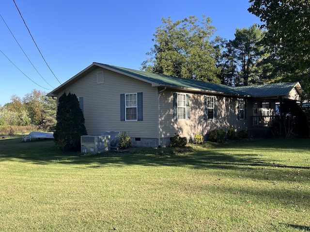 view of side of home featuring a yard and central air condition unit