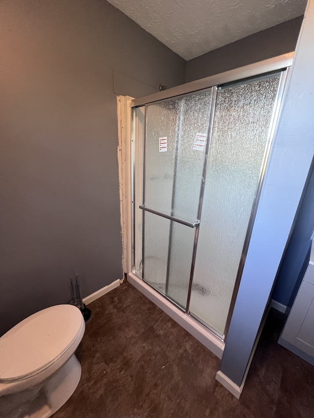 bathroom with toilet and an enclosed shower