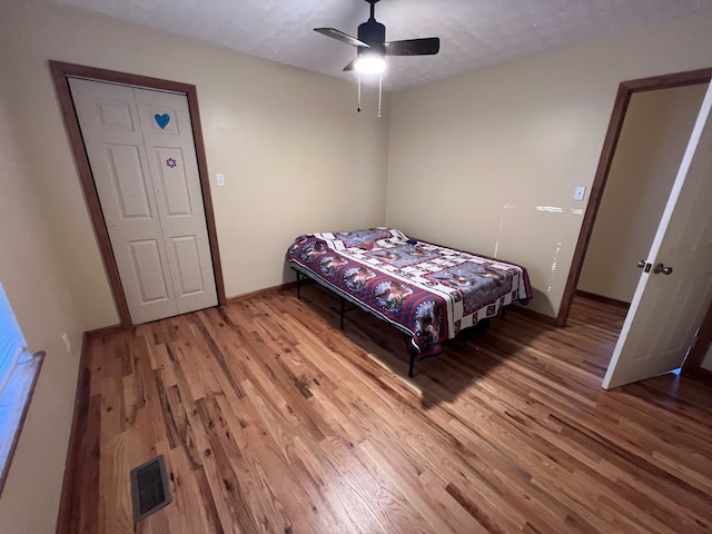 bedroom with ceiling fan, hardwood / wood-style flooring, and a textured ceiling