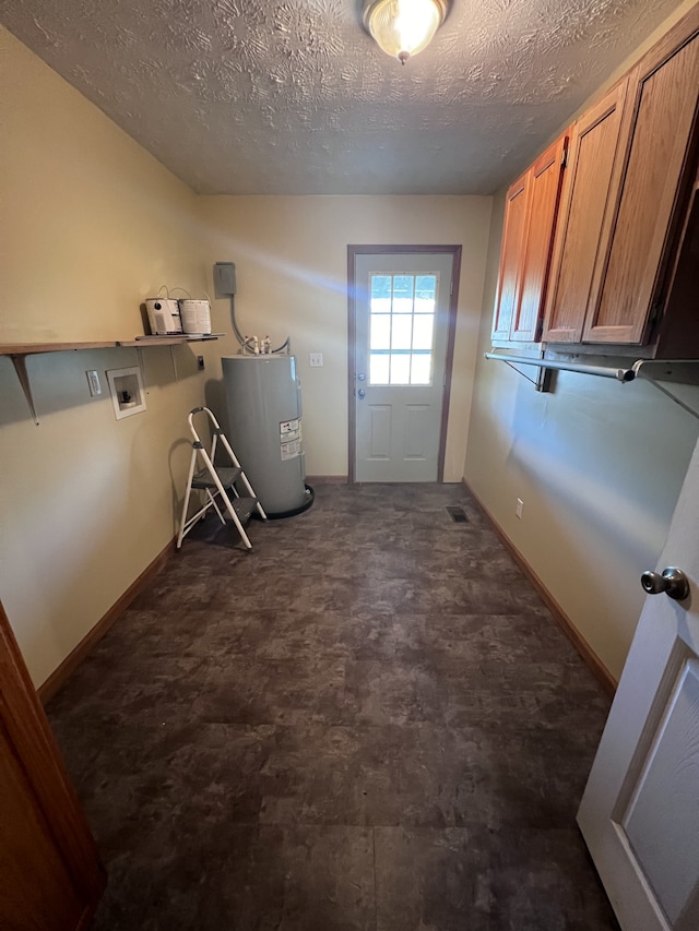 laundry area with hookup for a washing machine, a textured ceiling, electric water heater, and cabinets