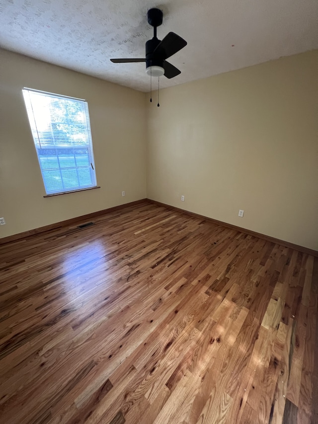 spare room featuring ceiling fan, a textured ceiling, and light hardwood / wood-style floors