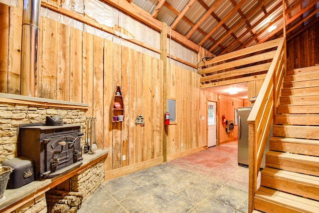 144 Abberly Ln, Hohenwald, TN 38462 - below grade area with a wood stove, stairs, wood walls, and freestanding refrigerator