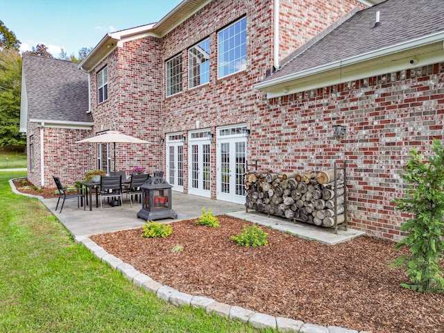 144 Abberly Ln, Hohenwald, TN 38462 - back of property featuring brick siding, a patio, a shingled roof, and a lawn