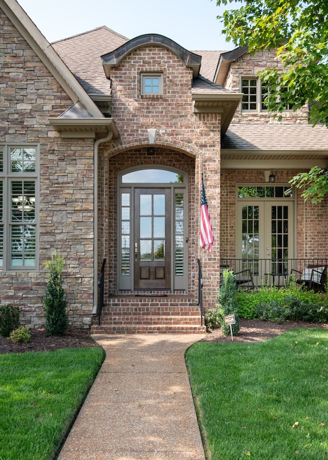 view of exterior entry with a lawn